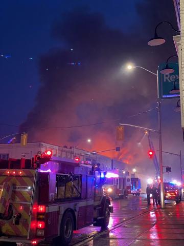 A fire engine on the street outside of a large fire in downtown Hanover