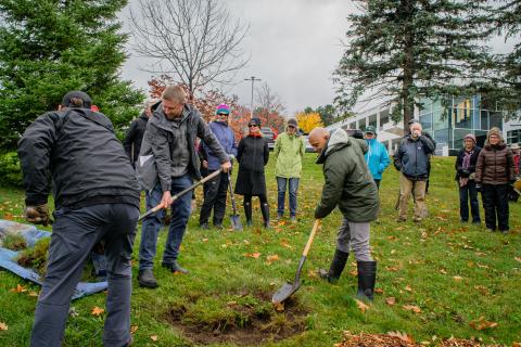 Participants plant trees at the administration building. 