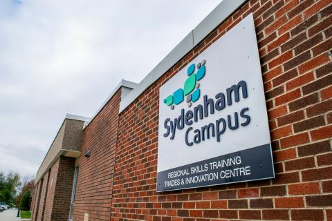 Photo of the Sydenham Campus building exterior and a sign reading Regional Skills Training, Trades and Innovation Centre