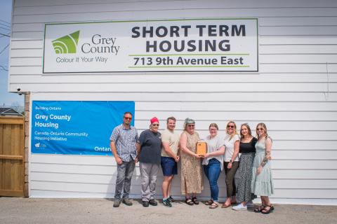 Staff in front of the short term housing building