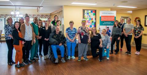 LTC Staff and residents posing with an RNAO Clinical Pathways banner